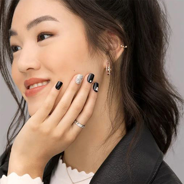 imPRESS Nails - Dynamite, zwarte nagels met glinsterende accentnagel, stijlvol gepresenteerd op een model.