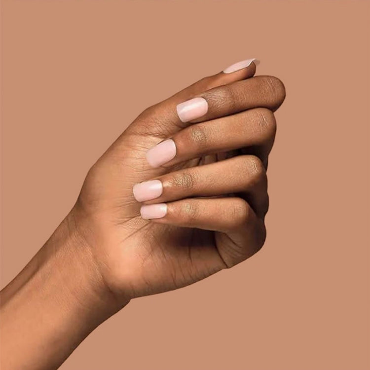 Bare But Better Nails - Nudies in een natuurlijke nude tint, elegant aangebracht op een hand met een zachte huidtint.