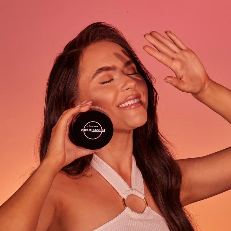 Cream Bronzer - Bronze in een zwarte verpakking, aangebracht op de huid van een model met een stralende glimlach.