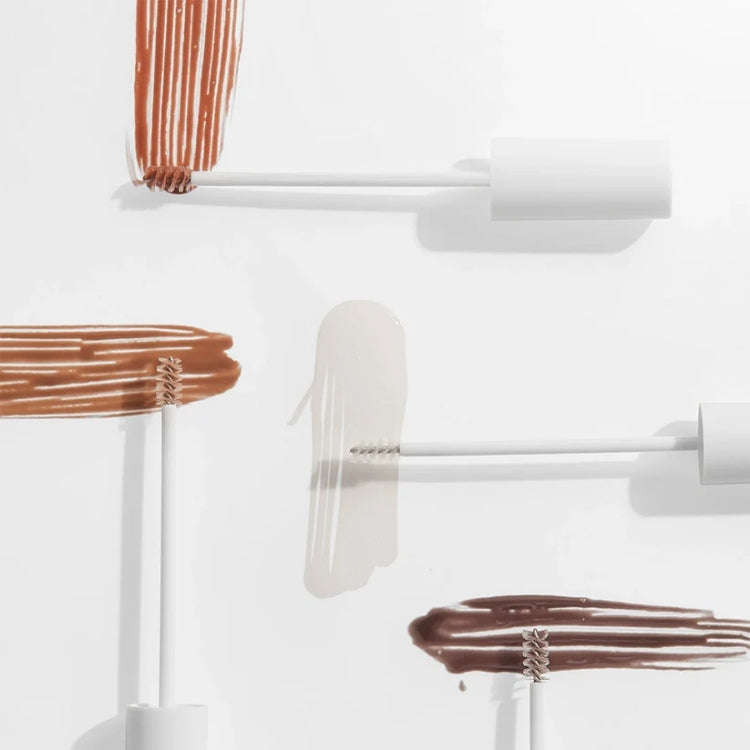 Incredibrow Brow Glue in verschillende kleuren met witte verpakking en applicator, ideaal voor het stylen van wenkbrauwen.